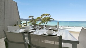 A dining table set for two with a view of the sea. - Apartment 25 Kalimna (Lorne)