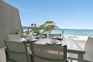 A dining table set for two with a view of the sea. - Apartment 25 Kalimna (Lorne)