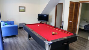 Relax in this cozy space with a pool table, TV, and comfortable seating area.