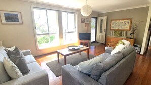 Ein Wohnzimmer mit einer Sofagarnitur, einem Couchtisch und einem Fernseher.