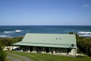 A building with a green roof overlooking the ocean.
