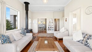 A spacious living room with a fireplace, sofas, a coffee table, and a bookshelf. - The White House -Prime Location & Oozing Character (Apollo Bay)