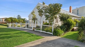 A residential house with a white fence, green lawn, and a clear sky. - The White House -Prime Location & Oozing Character (Apollo Bay)