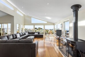A spacious living room with a large sectional sofa, a fireplace, and a television.
