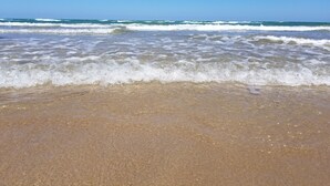 A beach with waves gently lapping onto the shore.