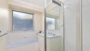 Une salle de bain avec une baignoire, une douche et un lavabo.
