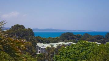 A coastal property with multiple buildings, lush greenery, and a view of the sea.