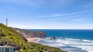 A coastal landscape with a lighthouse, beach, and ocean. - Beach View (Fairhaven)