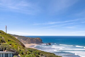 A coastal landscape with a lighthouse, beach, and ocean. - Beach View (Fairhaven)