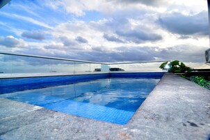Una piscina al aire libre, sillones reclinables de piscina