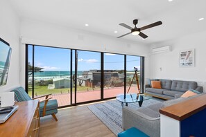 A spacious living area with a large sliding glass door leading to a balcony overlooking the ocean. - Casino Views (Apollo Bay)
