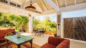 A covered outdoor seating area with a table, chairs, and a sofa. - The blue beach house (Quinns Rocks)