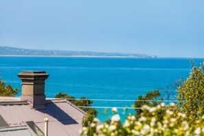 A coastal view with a clear sky, a body of water, and a distant shoreline with buildings. - Valetta (Lorne)