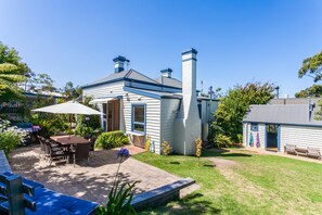 Une maison avec un patio, du mobilier d’extérieur et une cheminée.