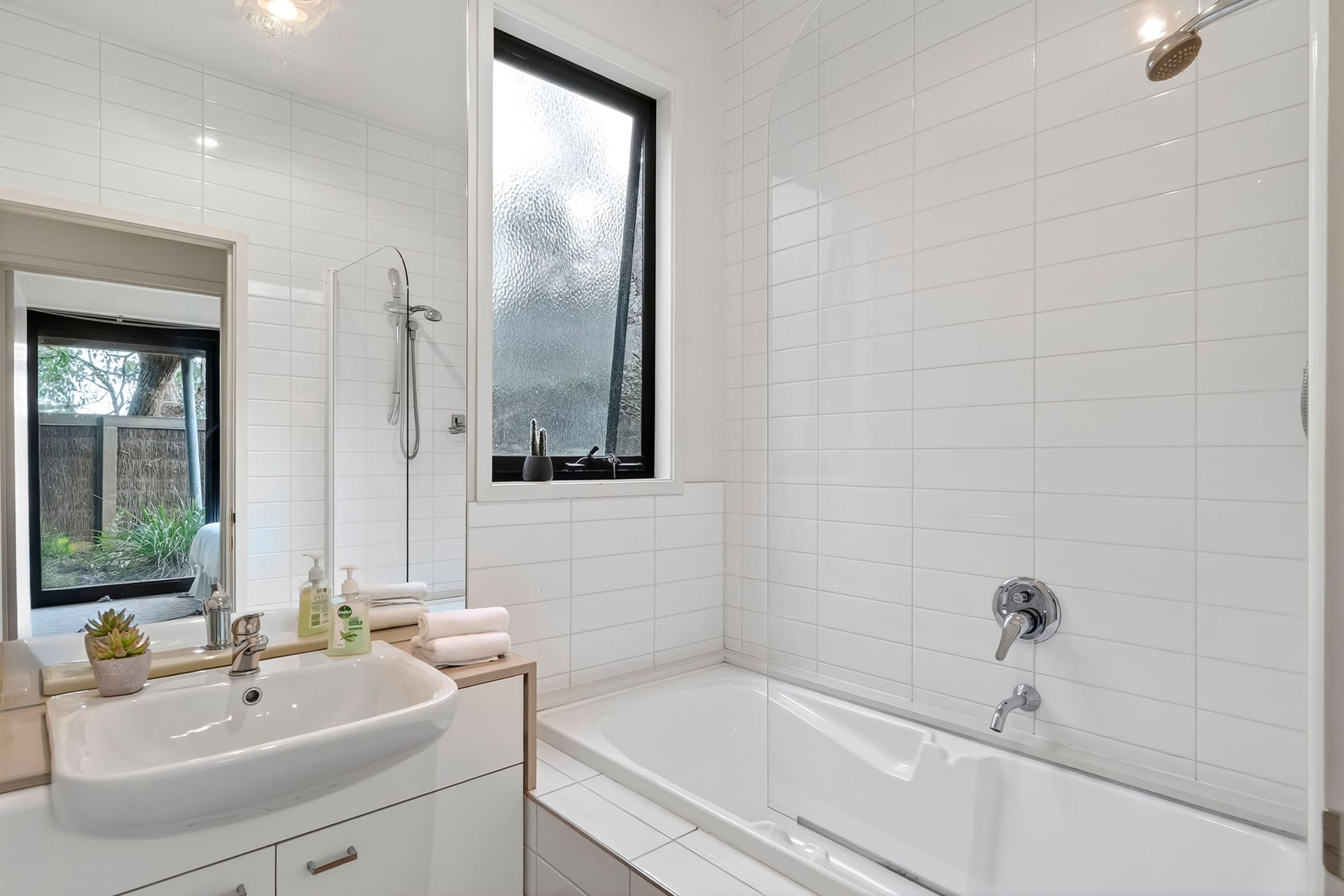 Ein modernes Badezimmer mit Waschbecken, Waschtisch und Badewanne.