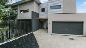 A modern two-story building with a garage and a covered driveway. - Allawah (Lorne)
