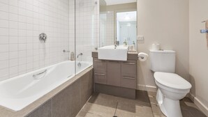 Un bagno moderno con una vasca, un water e un lavandino.