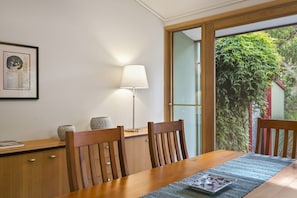 Ein Essbereich mit einem Holztisch, Stühlen, einer Lampe und einem gerahmten Bild an der Wand.