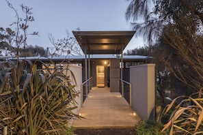 A modern building with a covered walkway leading to a door.