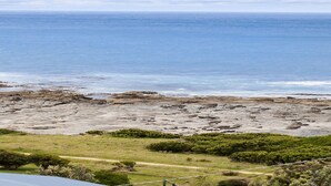 A coastal landscape with a rocky beach and a clear view of the ocean. - Cape Marengo (Marengo)