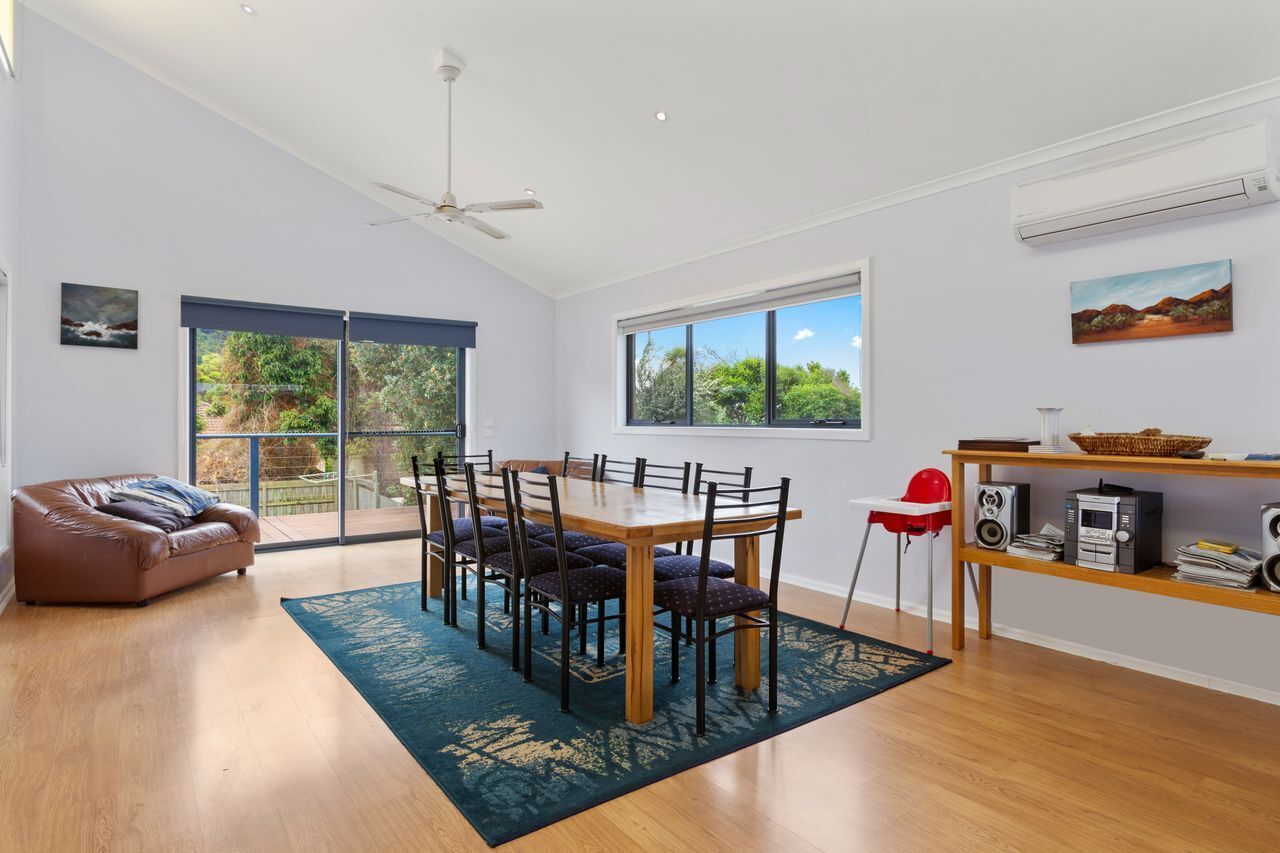 A modern dining area with a table, chairs, and a ceiling fan.