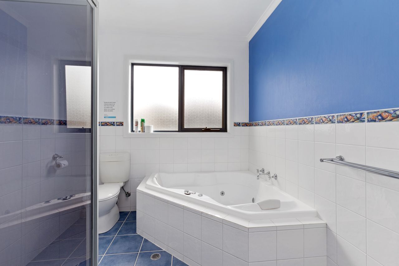 Ein Badezimmer mit Badewanne, Toilette und Duschbereich.