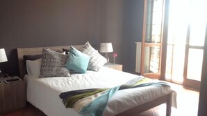 A bedroom with a bed, a nightstand, a lamp, and a window. - Fantastic house in Monferrato! (Tonco)