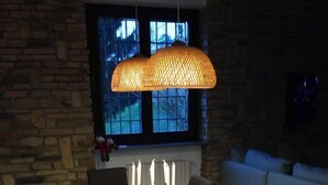 A dining area with a wooden table, black chairs, a red table runner, and a hanging light fixture. - Fantastic house in Monferrato! (Tonco)