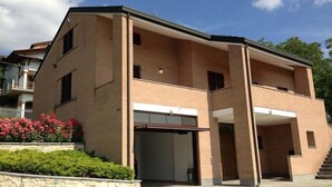 A two-story building with a flat roof, a central entrance, and a visible staircase leading to an upper level. - Fantastic house in Monferrato! (Tonco)