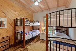 A bunk bed room with wooden walls and a ceiling fan. - Otway Views (Skenes Creek)