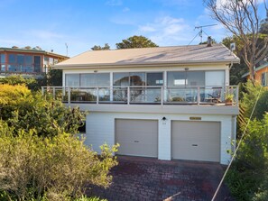 A two-story house with a balcony, garage doors, and a clear sky. - Otway Views (Skenes Creek)