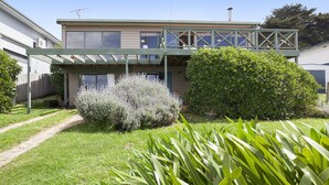 A two-story house with a covered porch and a large bush in the front yard. - Seamoon - Apollo Bay (Apollo Bay)