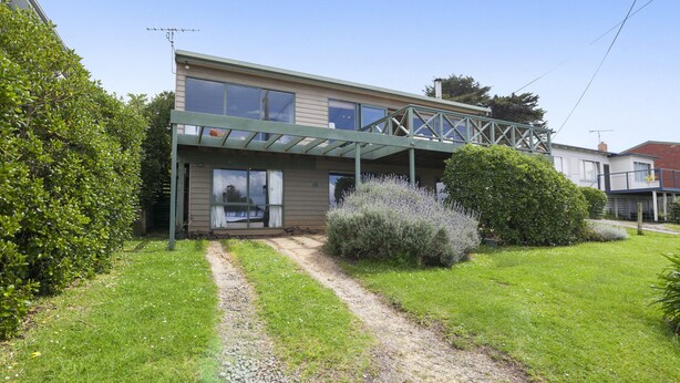 A two-story house with a covered porch and a gravel driveway. - Seamoon - Apollo Bay (Apollo Bay)