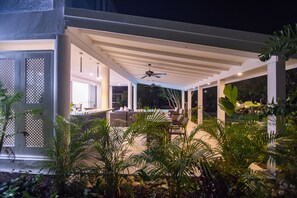 Un espace extérieur aménagé en terrasse, doté d’un ventilateur de plafond, de sièges et d’une piscine.