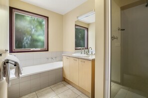 Une salle de bain avec une baignoire, un lavabo et un miroir.