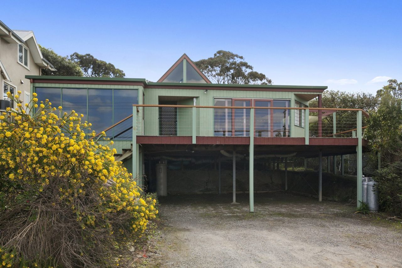 A two-story house with a balcony, a garage, and a driveway.