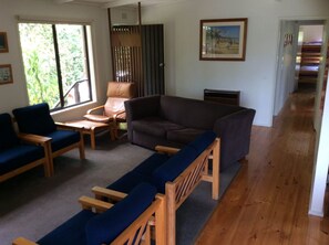 A living room with a brown sofa, blue chairs, and a wooden coffee table. - Bardham (Skenes Creek, Apollo Bay)