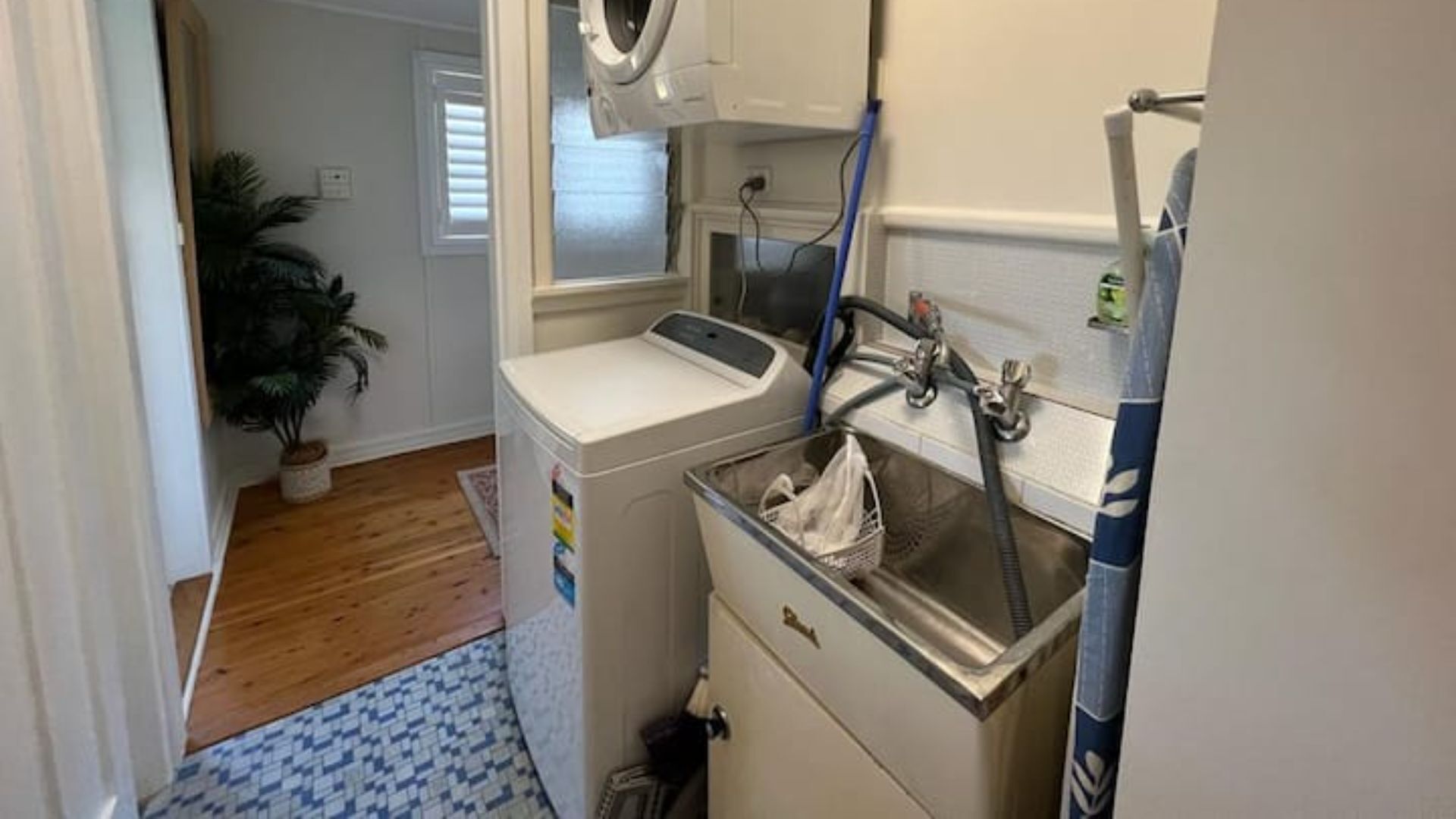 A compact laundry room with a washing machine, a dryer, and a sink.