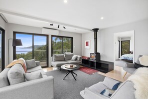 A modern living room with a sofa, coffee table, and a fireplace.