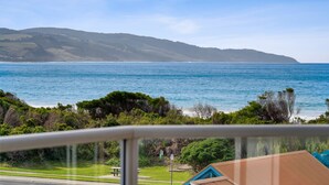 A coastal view with a clear sky, a body of water, and distant hills.