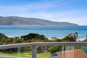 A coastal view with a clear sky, a body of water, and distant hills.