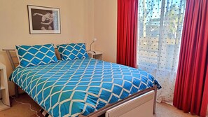 2 dormitorios y tabla de planchar con plancha