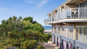 Un edificio moderno de varios pisos con balcones con vistas a la costa.