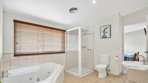 Un baño moderno con bañera, inodoro, ducha y lavamanos.