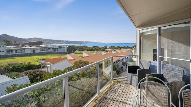 Un balcón con vista a una zona residencial y colinas.