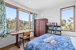 A bedroom with a bed, a desk, a chair, a wardrobe, and a bookshelf. - Steppy Beach Retro (Aireys Inlet)