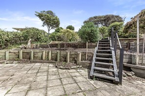 A wooden staircase leading up to a wooden deck with a stone pathway. - Absolute Beachfront Views Apollo Bay (Apollo Bay)