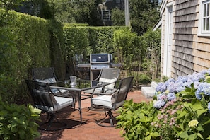 An outdoor patio with a grill, four chairs, and a table. - Renovated Cottage off Main Street- Great Location (Nantucket)