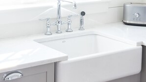 A modern kitchen with a white sink, chrome faucet, and a toaster on the counter. - Renovated Cottage off Main Street- Great Location (Nantucket)