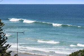 A beach with waves and a clear sky.